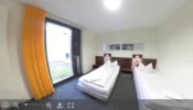 A 360° panoramic view of a two-bed room