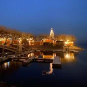 Das abendliche Ufer mit Weihnachtsmarkt
